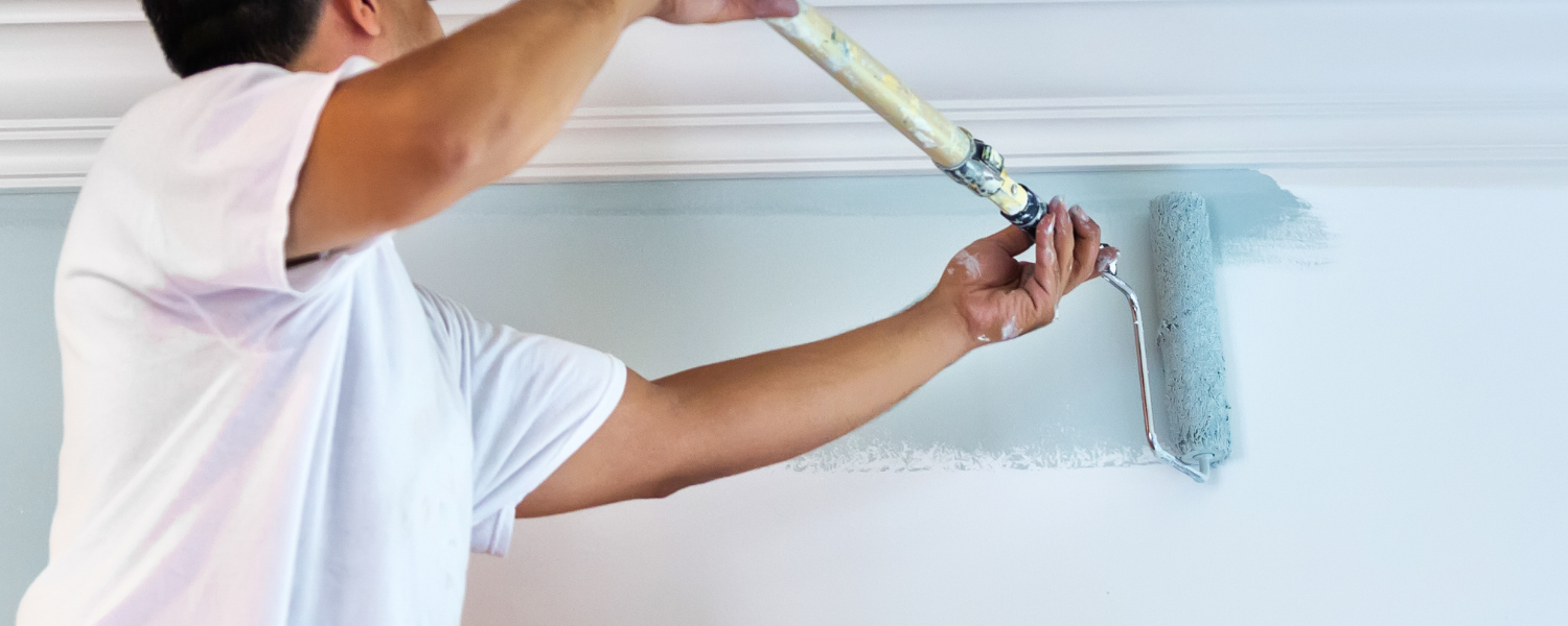 Person painting a ceiling with a roller